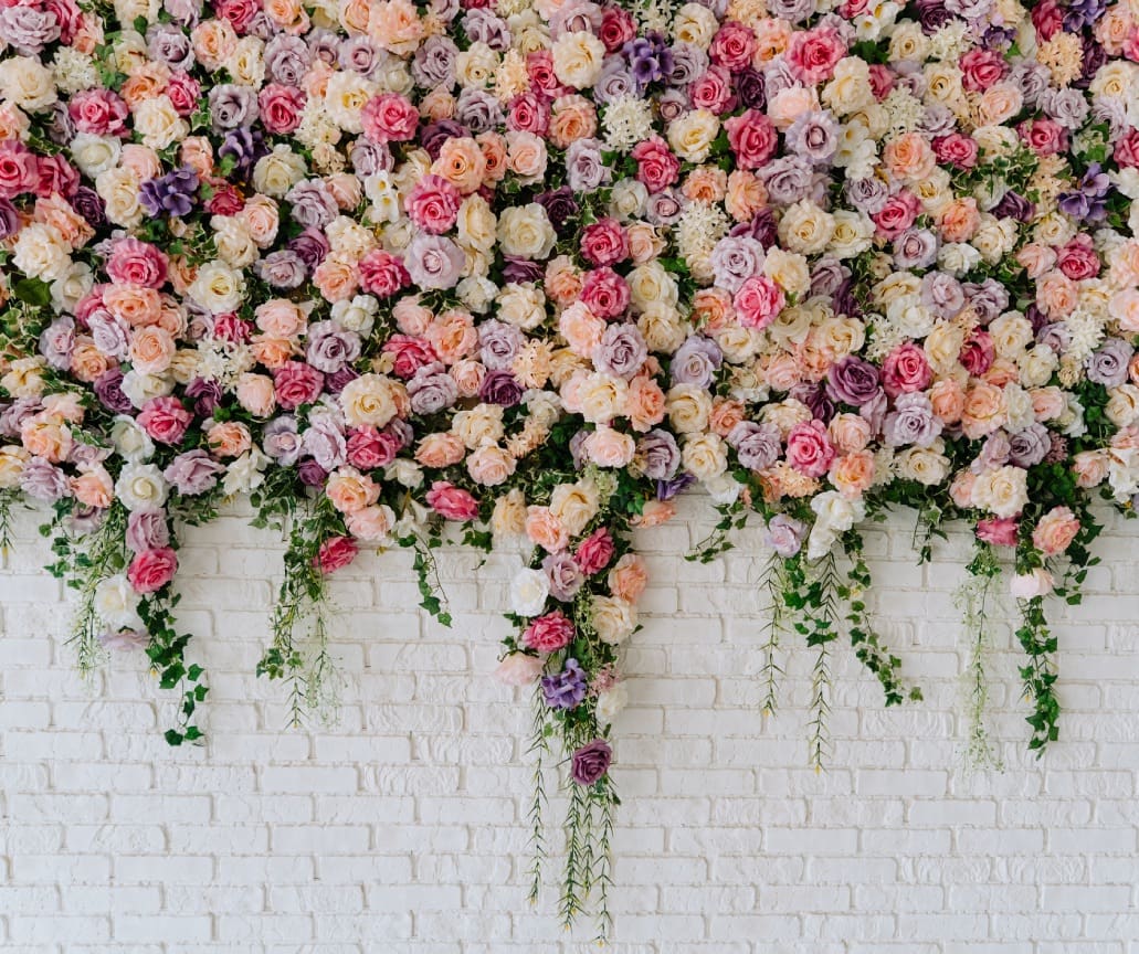 Floral wall backdrop on white brick.
