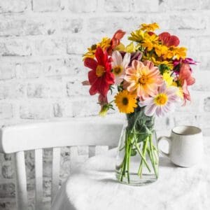 Colorful flowers in a glass vase on table.