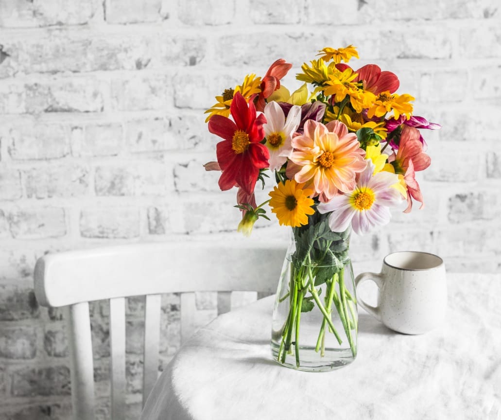 Colorful flowers in a glass vase on table.