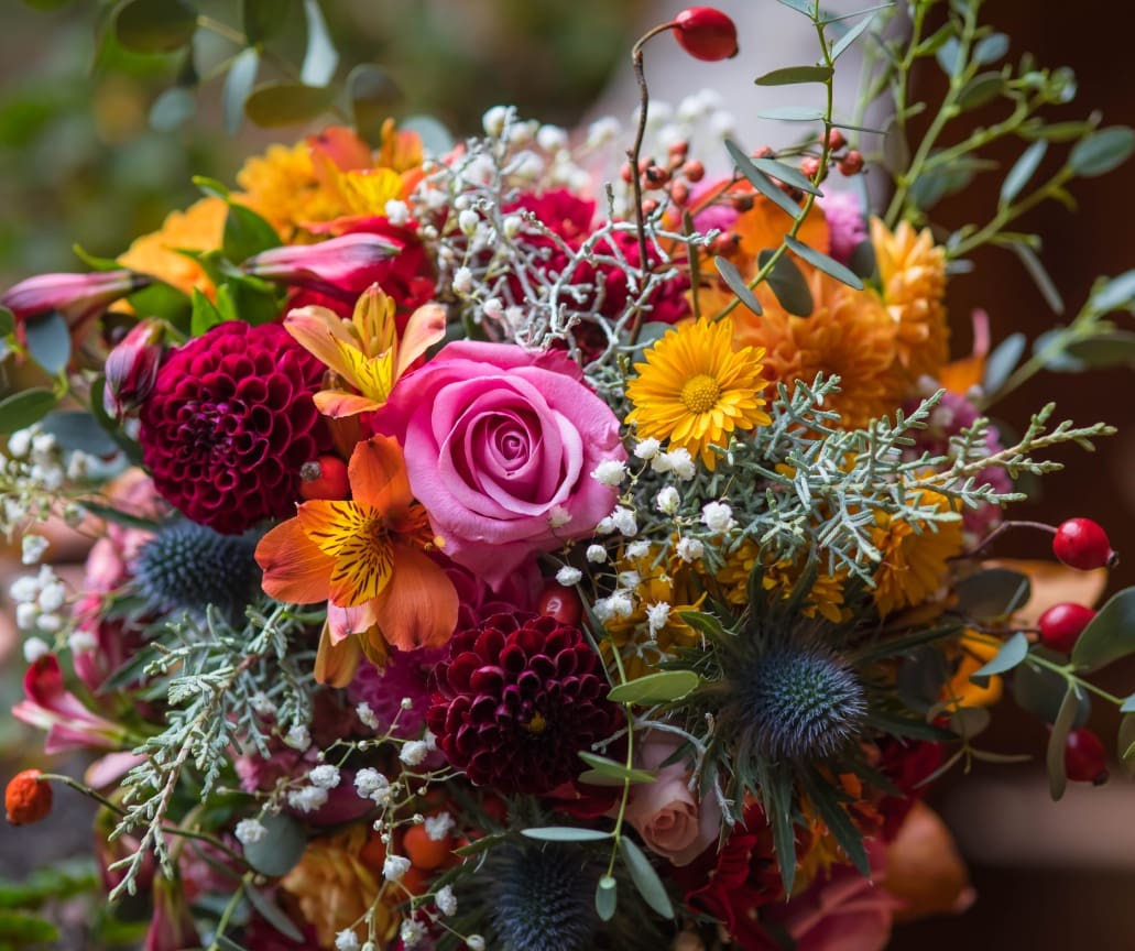 Colorful bouquet with pink rose and greenery.