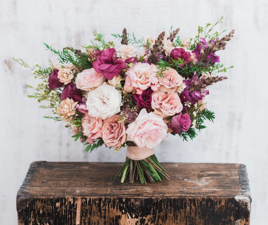Pink and purple bridal bouquet on wood.