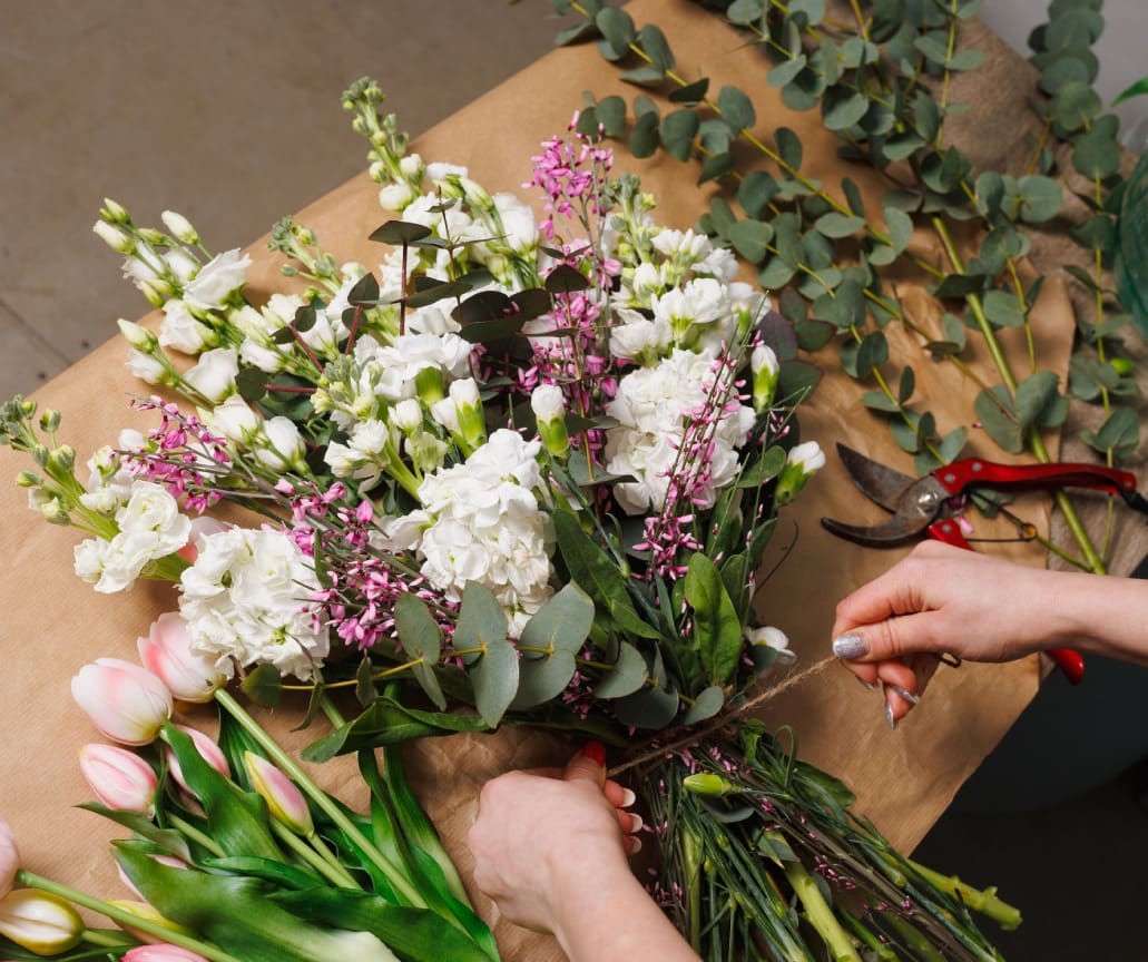 White and pink flowers being tied with twine.
