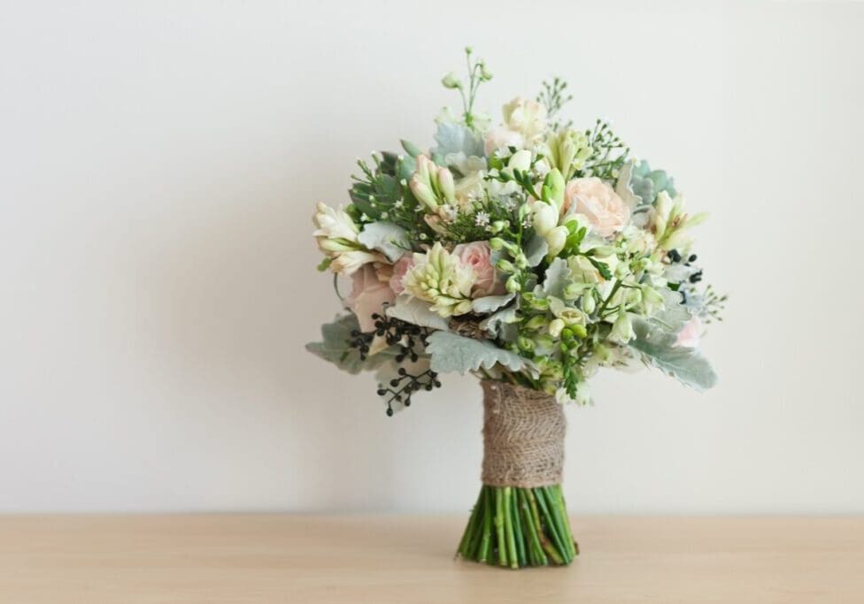 Wedding bouquet with pink roses and greenery.